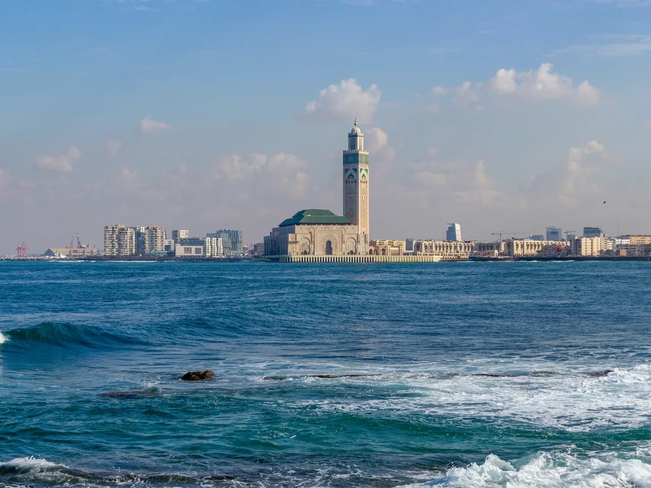 Panoramic view of Casablanca featuring the Hassan II Mosque and restaurants along the Ain Diab corniche